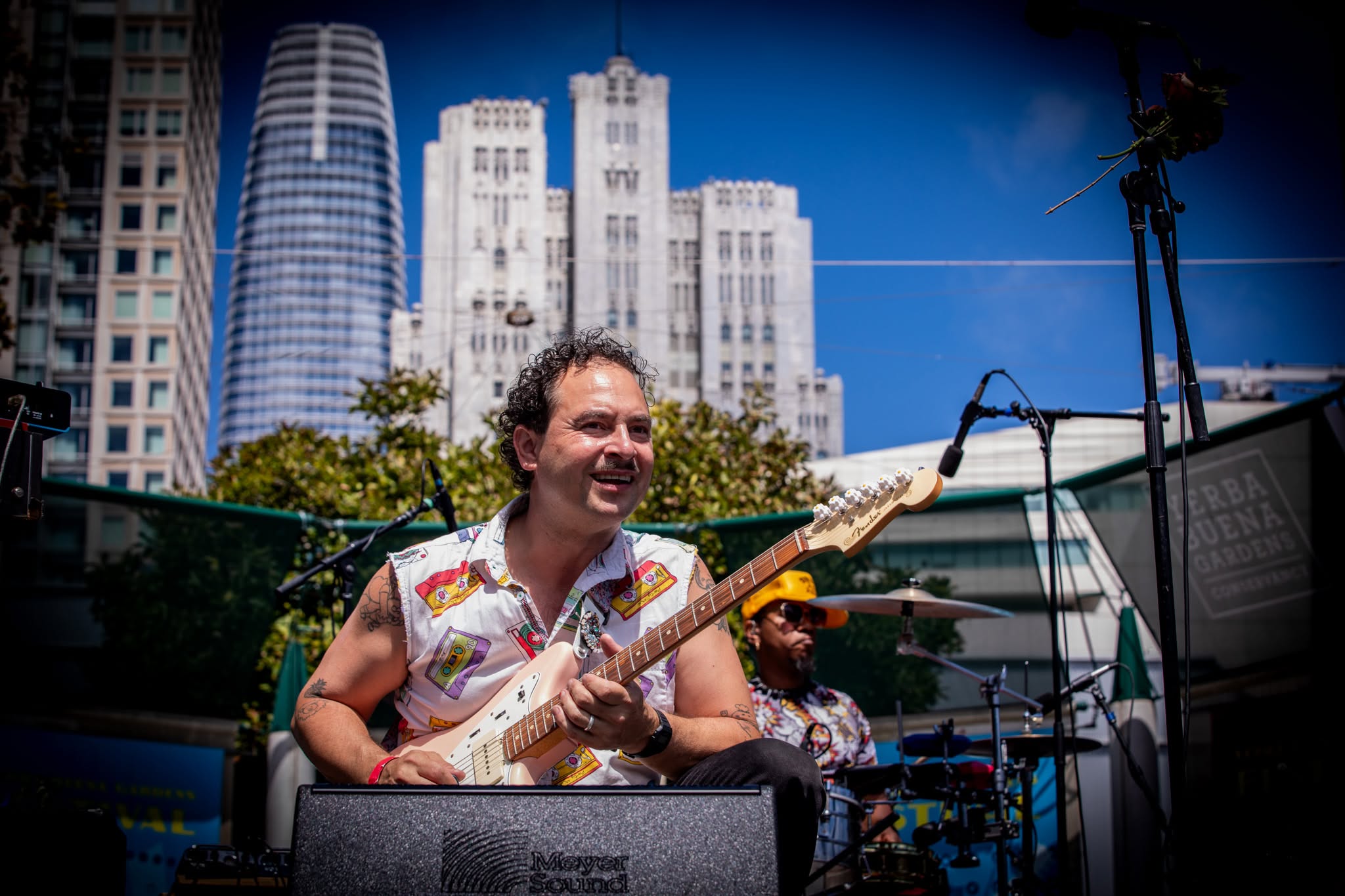 Camilo Landau smiling on stage with the San Francisco skyline behind him